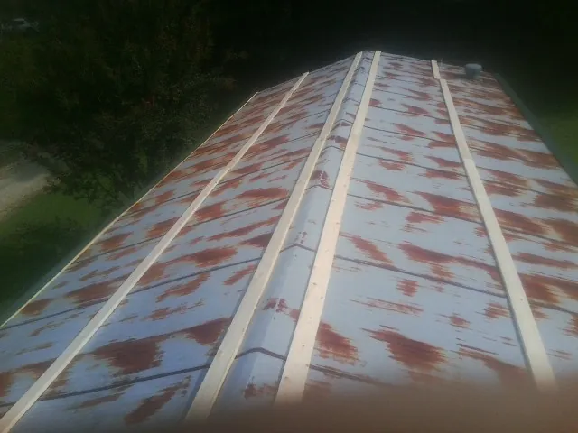 Rusted metal roof panels with new wood purlins before replacement — Storm Damage Roof Repair in Chatom by Roofing Brothers