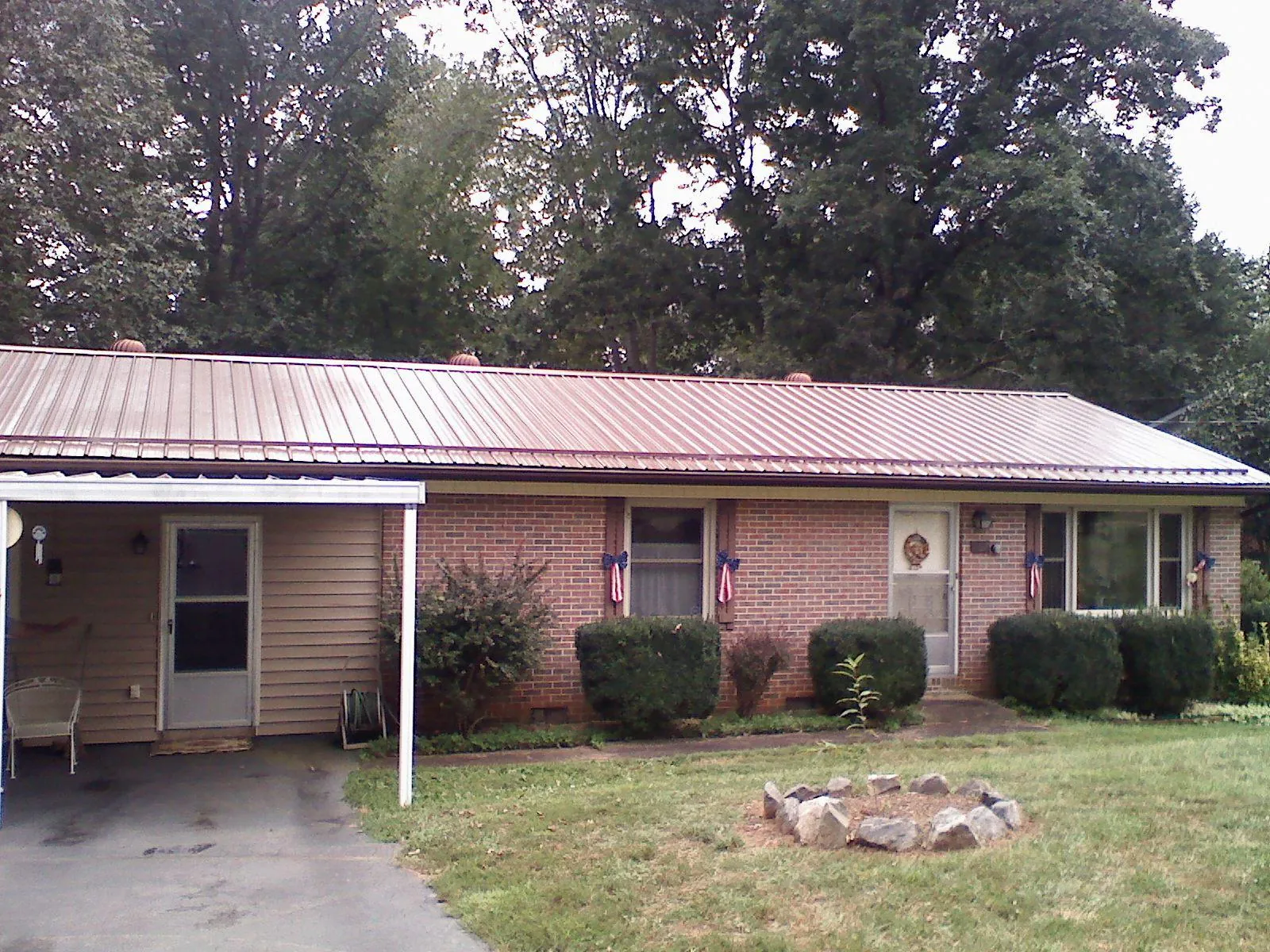 Bronze metal roof and carport on a brick ranch home — Roof Repair work by our crew in Chatom
